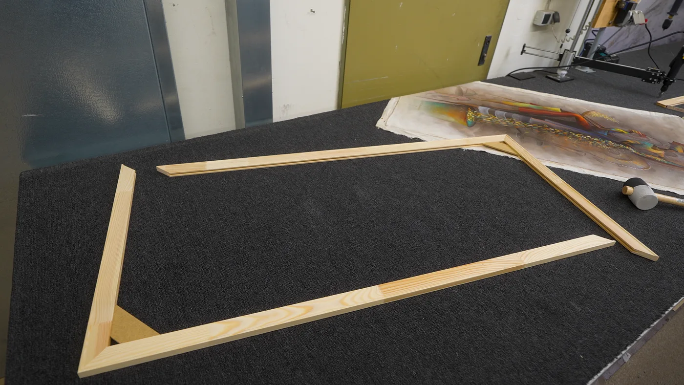 Deux formes en L assemblées en baguettes de châssis sur l'établi