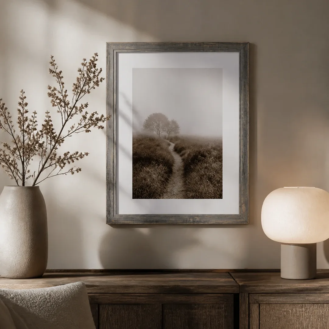 Cadre vintage gris patiné avec photo de paysage au mur, au-dessus d'une commode en bois