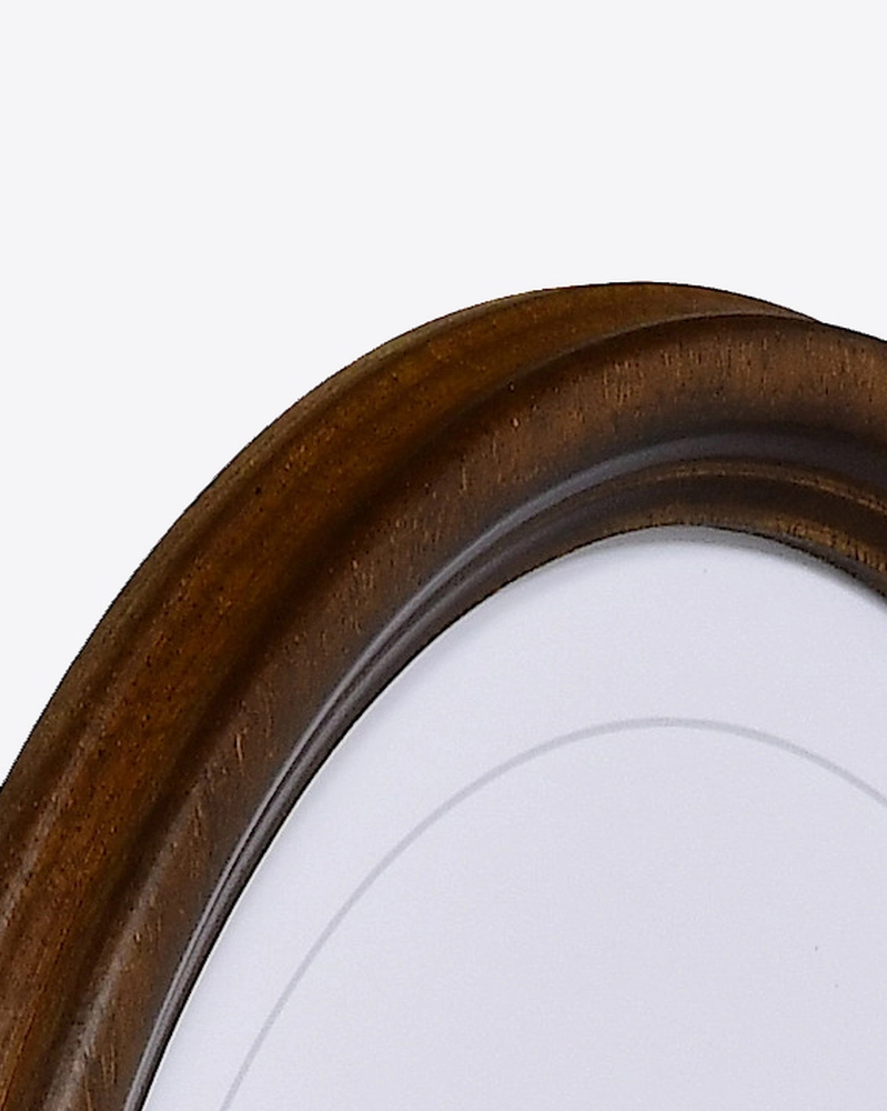 Tu découvres ici le coin d'un magnifique cadre ovale en bois, d'un marron chaud et élégant, parfait pour MonCadrePréféré.
